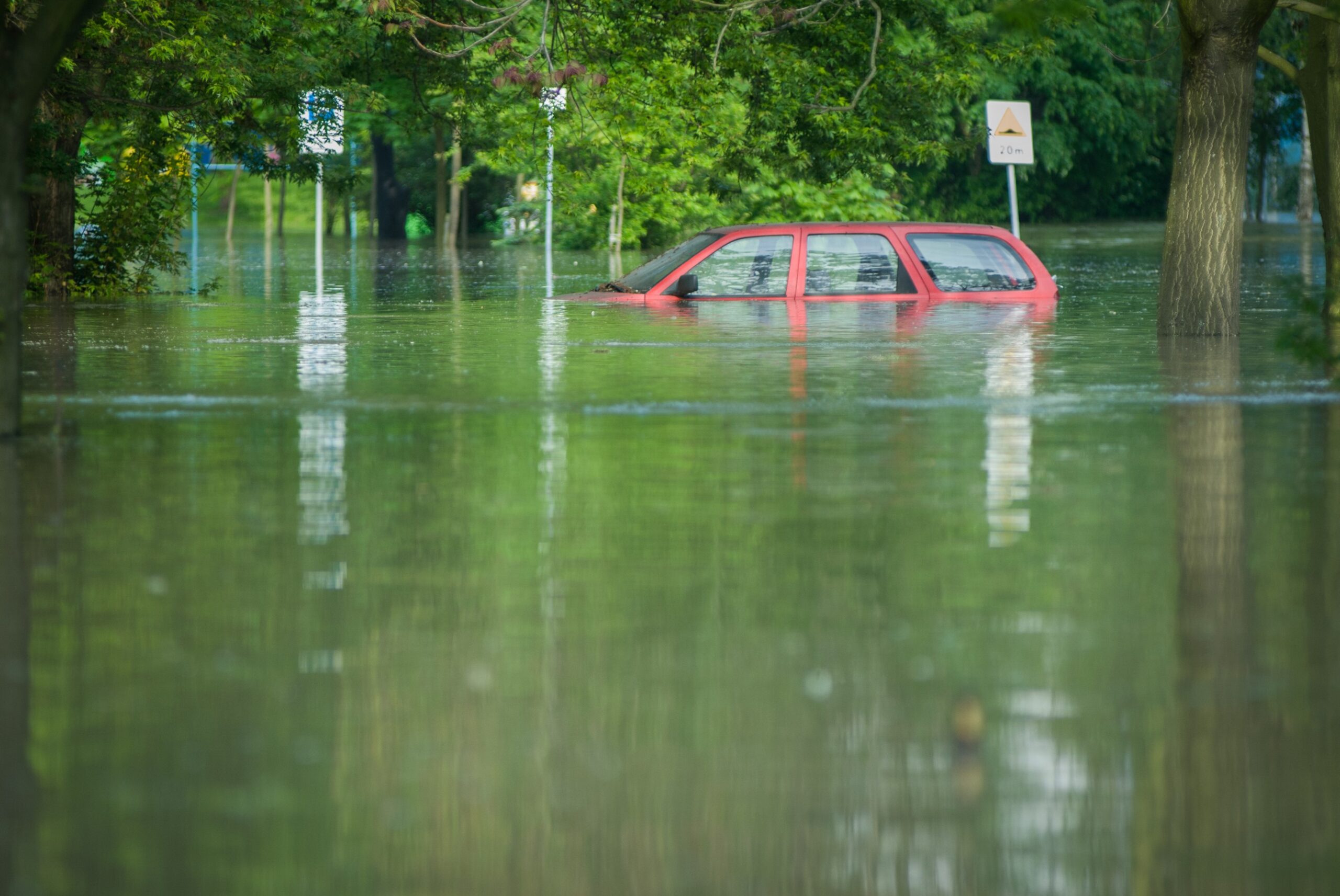 A car being partially underwater in a flooded street