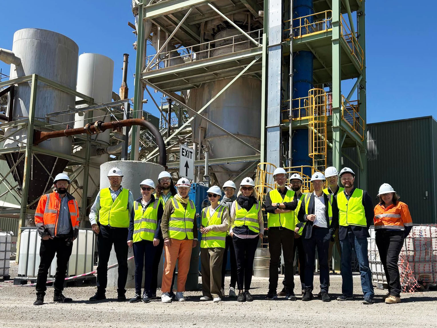 Group of people with helmets in front of a factory in Australia.