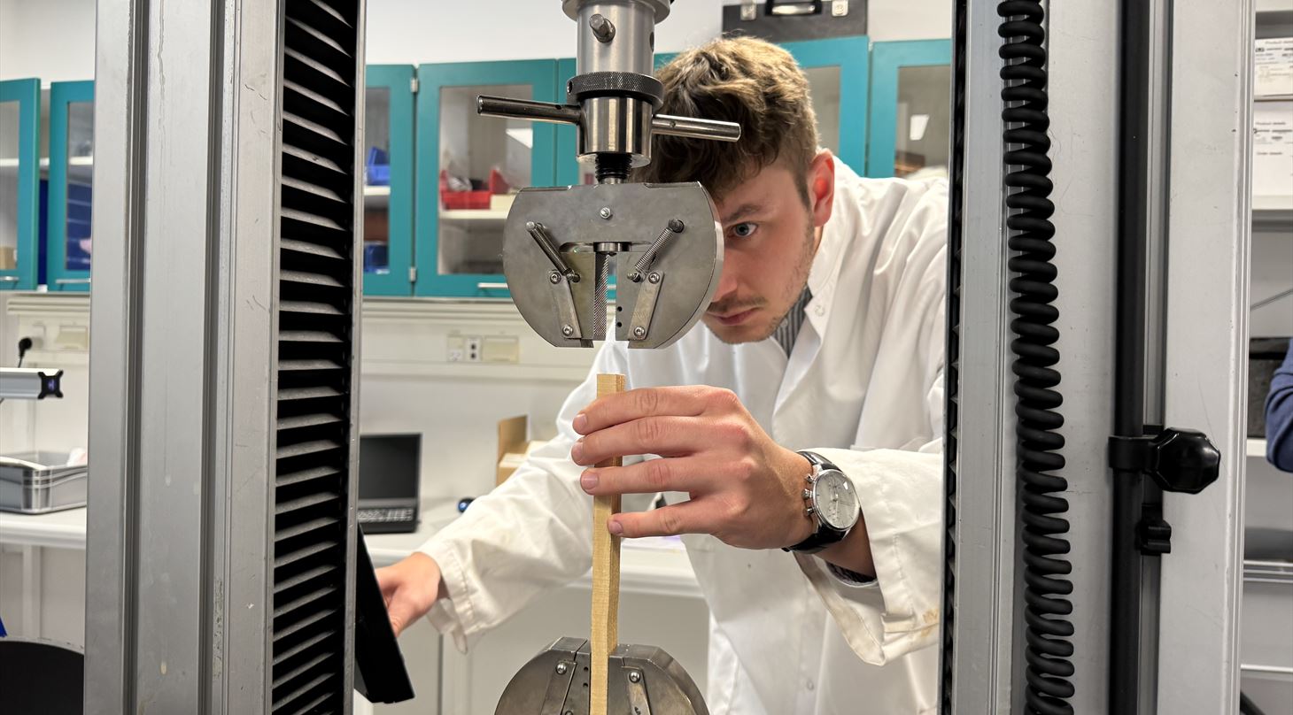 person in white lab coat in a laboratory wooden board